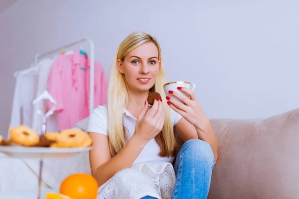 Sorrindo Mulher Bonita Senta Sofá Mantém Xícara Café Biscoito Suas — Fotografia de Stock