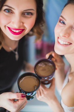 Bir fincan kahve el ile iki neşeli kız