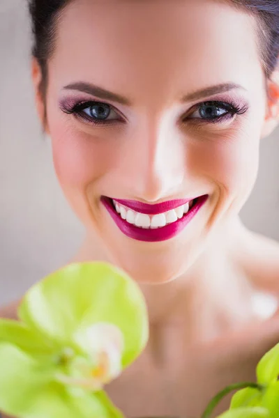 Beautiful face of woman with makeup and sincere smile