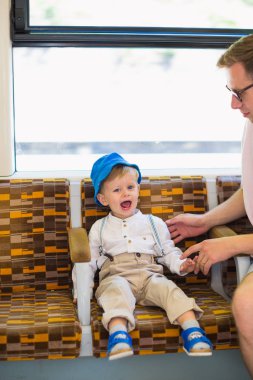 Küçük şirin neşeli çocuk bir otobüs babasının oturur.
