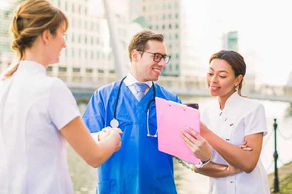 Jonge Knappe Dokter Schudt Hand Van Verpleegkundige Toont Map Naar — Stockfoto