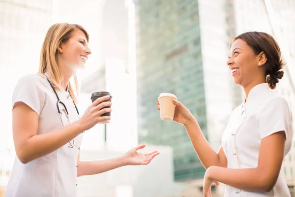 Duas Jovens Enfermeiras Felizes Ficam Com Xícaras Café Sorriem Tempo — Fotografia de Stock