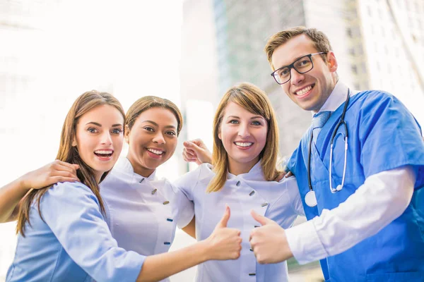 Чотири Щасливі Медичні Працівники Стоять Разом Два Показують Великі Пальці — стокове фото