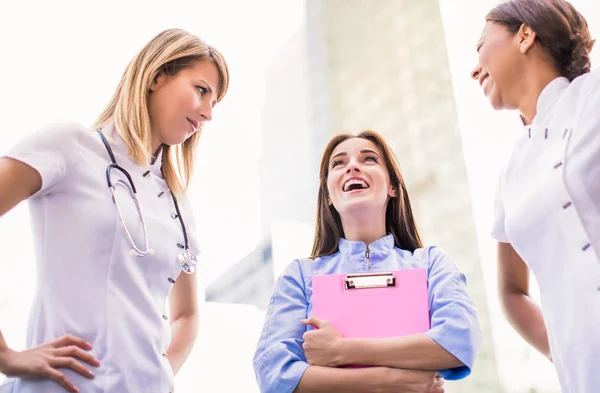 Three Smiling Nurses Stand Together Outdoor Stock Image