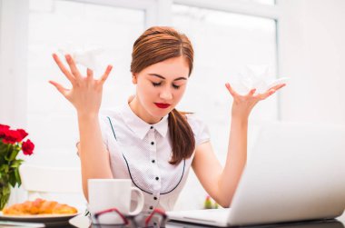 Kim ofiste masada oturur ve peçeteler elinde tutan genç gergin ofis çalışanı portresi