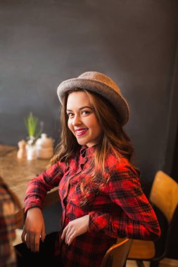 Güzel, neşeli bir kadın bir kafede masada oturur