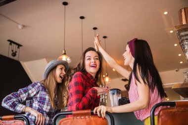 Neşeli öğrenciler oturup bar ve iki tane de bel soğukluğu birbirlerine bir kafede eller