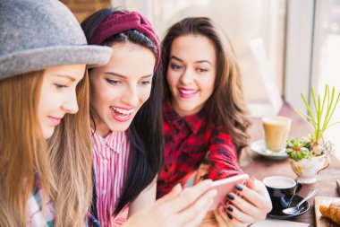 Genç kız öğrenci masada pencerenin yakınındaki ve telefon, Cafe mola zamanında bak