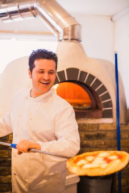 Şef pizza fırın pizza küreği restoranda mutfaktaki yardımıyla çizer