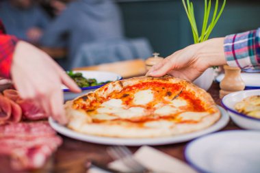 Pizza insanların ellerini almak, restoranda masanın üzerine kapatın