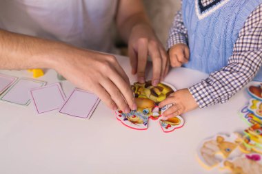 Yakın çekim bir çocuk ve bir masada oturan ve kapalı bulmaca yapma adam
