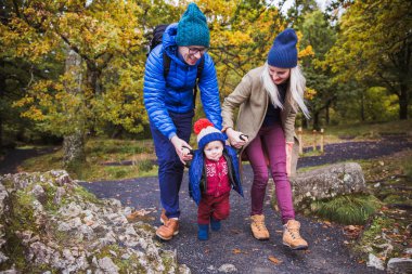 Mutlu anne küçük oğlu elinde tutmak ve onu doğa üzerinde gitmek için yardım