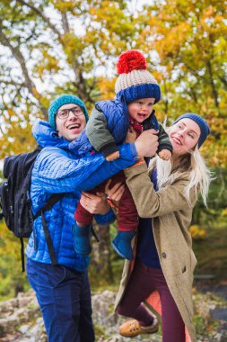 Yakın çekim gülümseyen baba ve anne doğa çerçevede mutlu sevimli oğlu tutmak