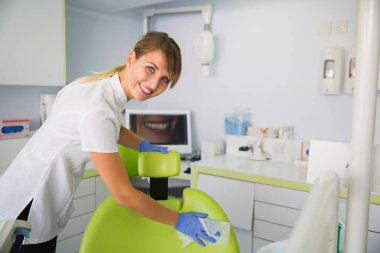 Gülümseyen kadın diş hekimi diş hekimi sandalye yordamlar sonra Temizleme.