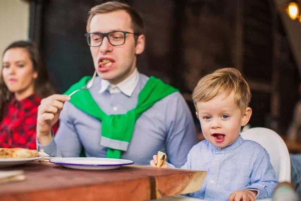 小さな男の子が彼の父とテーブルに座るし 彼らは レストランで食べる幸せのクローズ アップ — ストック写真