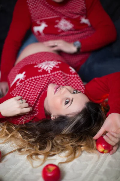 Молодая Нежная Беременная Женщина Лежит Рядом Мужем Помещении Держит Яблоко — стоковое фото