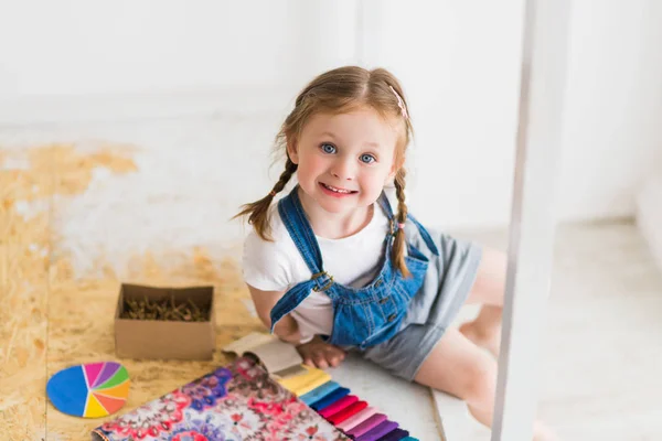 Ένα Μικρό Κορίτσι Που Κάθεται Ένα Παχνί Και Επιλέγει Χρώμα — Φωτογραφία Αρχείου
