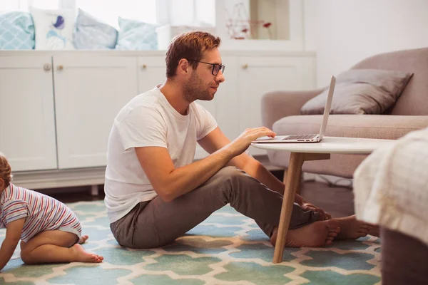 Young Concentrated Father Sitting Floor Room Using Laptop His Little — Stockfoto