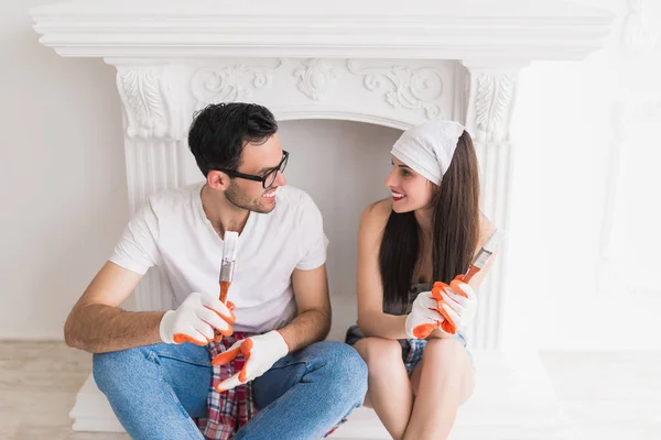 Joven Pareja Sonriente Hace Reparaciones Casa Sientan Mantienen Pinceles Para —  Fotos de Stock