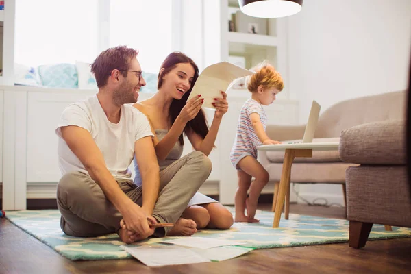 Jonge Glimlachend Ouders Zittend Vloer Kijken Naar Documenten Kamer Welke — Stockfoto