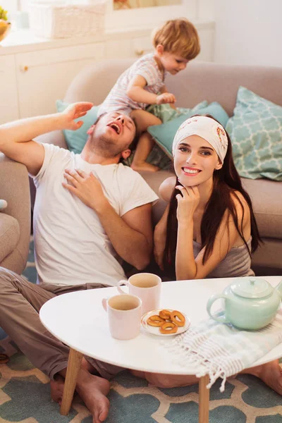 Los Padres Sonrientes Jóvenes Sentados Mesa Suelo Habitación Pequeño Hijo — Foto de Stock