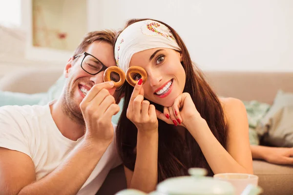 Portrait of young romantic couple in the room who looking through the bagels