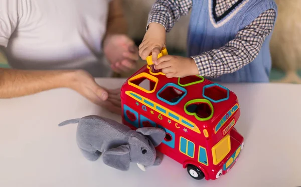 Primo Piano Giocattoli Sul Tavolo Uomo Con Bambino Seduto Accanto — Foto Stock