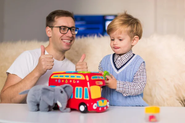 Молодий Щасливий Батько Грає Іграшки Своїм Маленьким Сином Приміщенні Показує — стокове фото