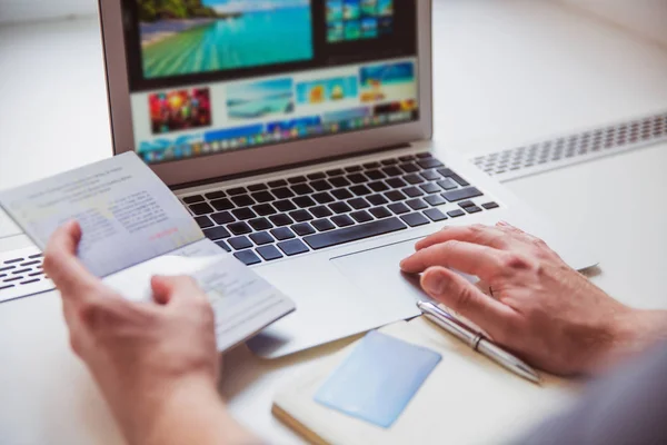 Fotografia Computer Portatile Che Usando Uomo Tenendo Passaporto Mano All — Foto Stock