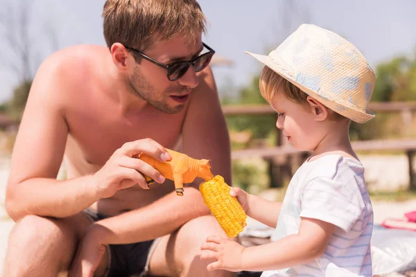 Genç portresi ile sahilde küçük sevimli oğlu oynayan baba