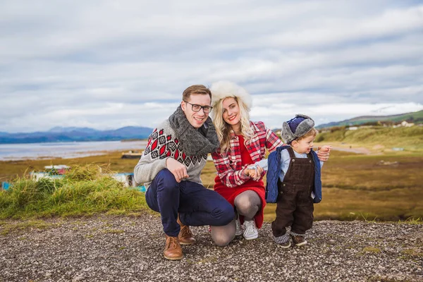 Happy wonderful family on the road against the background of  a lake and the mountains