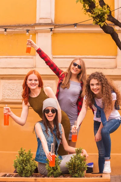 Fiatal Stílusos Mosolygós Diákok Nők Vezetése Palackok Kezébe Szabadban — Stock Fotó