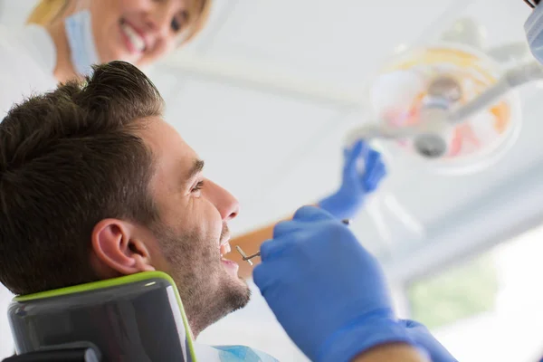 Overview of dental caries prevention. Man in the dentist\'s chair during a dental procedure. Healthy smile.