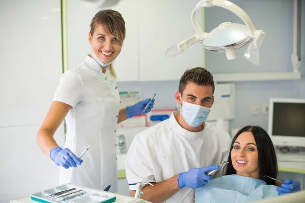 Jonge Mannelijke Tandarts Zijn Assistent Behandelende Vrouwelijke Patiënt — Stockfoto