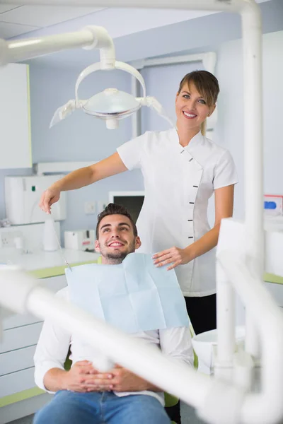 Imagem Dentista Feminino Ajustando Avental Paciente Masculino Antes Tratamento Clínica — Fotografia de Stock