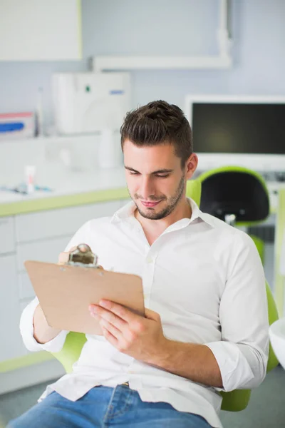 Yong Homem Bonito Sentado Cadeira Escritório Clínica Segurando Tablet — Fotografia de Stock