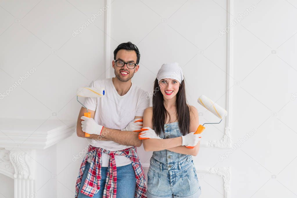 Portrait of young happy couple who does repair at home, they keep platens in hands