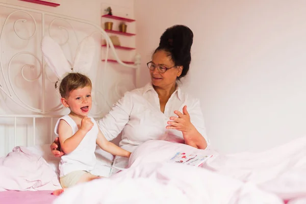 Glückliche Großmutter Auf Einem Bett Sitzend Mit Ihrem Kleinen Enkel — Stockfoto