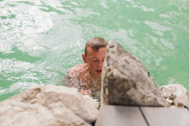 Taşları yakınındaki havuzunda mutlu çocuk