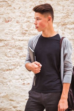 Ev duvar eski defterleri elinde tutan ve bir kenara görünüyorum yakınındaki açık duran genç adam portresi