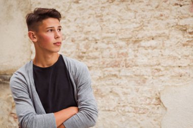 Eski ev duvara yakın açık duran ve bir kenara arayan genç adam portresi