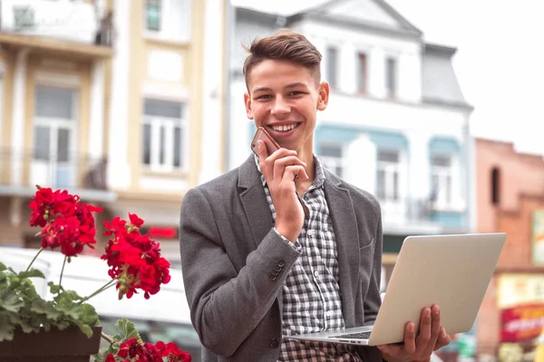 Retrato Jovem Sorridente Que Está Livre Usando Laptop Segurando Telefone — Fotografia de Stock