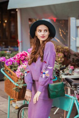 Bir bisiklet çiçekli açık ve seyir yakınındaki bir yana duran zarif genç kadın