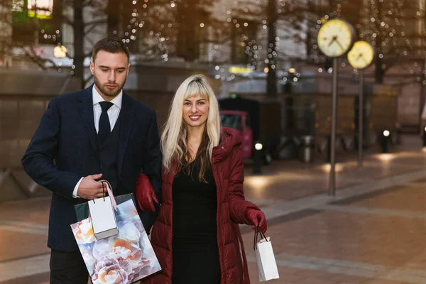优雅的年轻夫妇的肖像 他们在购物后拿着购物袋走到大街上 — 图库照片