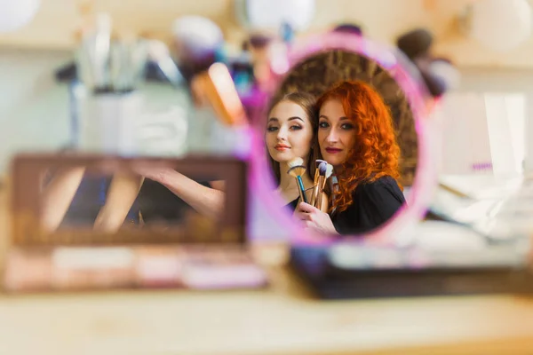 Den Vackra Unga Kvinna Och Nöjd Makeupartist Tittar Spegeln Makeup — Stockfoto