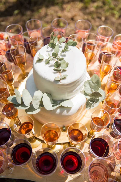 The beautiful cake on a table and glasses of wine around