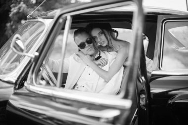 Kucaklama eski arabada oturan mutlu yeni evliler