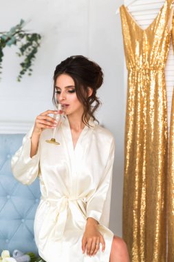 Bir sandalyede oturuyor ve kapalı bir şampanya içmek güzel genç mutlu gelin