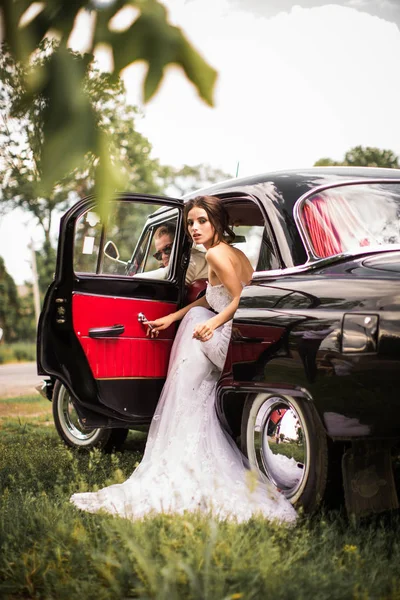 古い車の中に座って エレガントな美しい新婚夫婦 — ストック写真