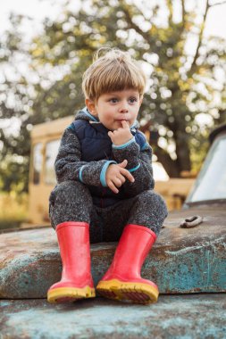 Eski kamyonda oturmuş ve onun parmak emme mutlu çocuk